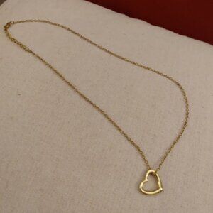 Gold tone open heart pendant on a chain necklace.